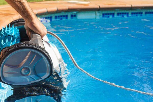 Man,Pulling,Out,The,Robotic,Pool,Cleaner,With,His,Hand.