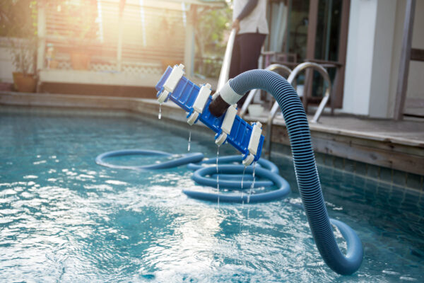 Man,Cleaning,Swimming,Pool,With,Vacuum,Tube,Cleaner,Early,In